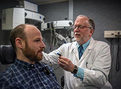  Dr. M. Patrick Feeney is director of the National Center for Rehabilitative Auditory Research. He is pictured with a VA employee, demonstrating a hearing test. <em>(Photo by David M. Moody, VA Portland Health Care System, Oregon)</em>