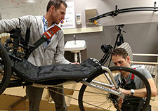  VA investigators Drs. John McDaniel and Paul Marasco adjust a tricycle designed to be used by a person with complete spinal cord injury and an implanted neural stimulation device. (Photo by Nathaniel Welch)