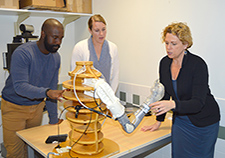 (From left) Research health science specialist Frantzy Acluche and project coordinator Sarah Ekerholm discuss the DEKA arm, an advanced upper-limb prosthesis, with Dr. Linda Resnik. (Photo by Kimberly DiDonato)