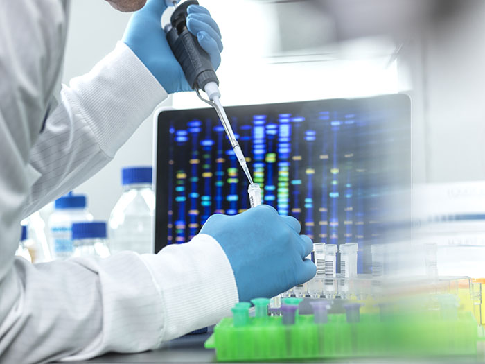 Scientist pipetting sample into a vial for DNA testing in High Wycombe, England, United Kingdom