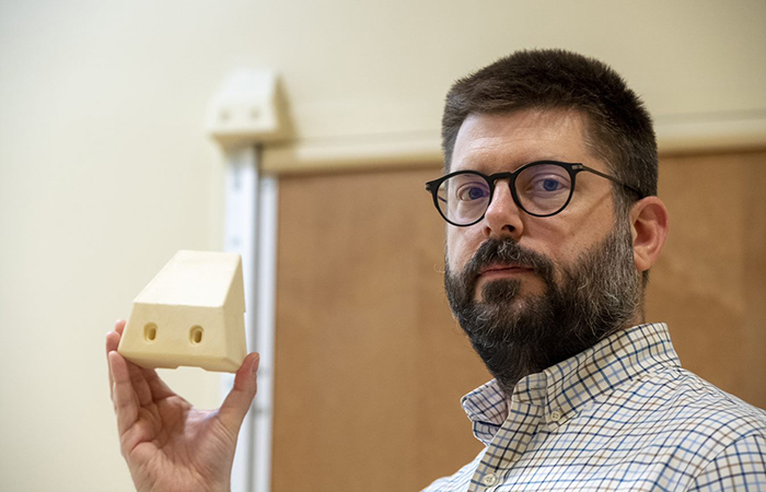 Frank Moore, the suicide prevention coordinator at VA Pittsburgh, displays the 3D block that was installed on all of the bathroom doors in patient rooms in the facility’s mental health wing to prevent a potential hanging.  (Photo by Bill George)