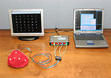 The photo shows the elements of the Wadsworth brain-computer interface. The user wears the electrode-fitted cap. (Photo courtesy of Wadsworth Center)  
