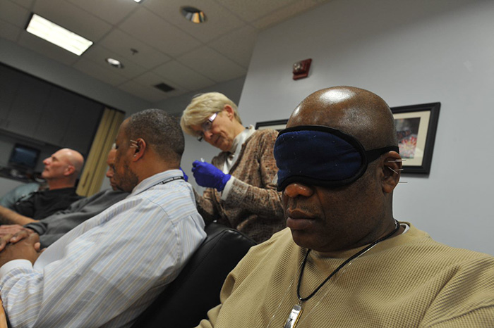 Veterans receive battlefield acupuncture treatment at the Washington DC VA Medical Center. An eye mask and soothing music in the background help create a relaxing environment. (Photo by Robert Turtil)