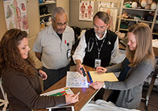 Clockwise: Infection preventionist Nicole Gerdts and Environmental Services staffer Bobby Cole discuss cleaning practices with researchers Dr. Eli Perencevich and Dr. Heather Reisinger at the Iowa City VA Health Care System. (Photo by Steve Smith) 