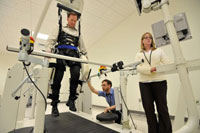 The Lokomat, a robotic treadmill that has been shown to help in stroke recovery, will be among the technologies explored at VA's new Center for Neurorestoration and Neurotechnology. Here, Veteran and VA staffer Doug Haldane (in harness) tests out the machine with the help of Doug Benedicto and Dr. Tara Patterson. (Photo by Frank Curran)