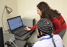 Dr. Laura Manning Franke reviews EEG results with a research participant, who is wearing an electrode cap.