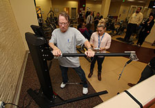 Roger Bergeron, who served in the Navy, works his hip abductors as exercise physiologist Katie Dondero adjusts the machine settings. (Photo by Mitch Mirkin)) 