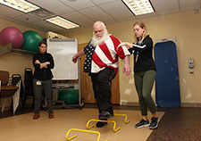 Army Veteran Gary Lucas navigates a hurdle exercise with the help of study coordinator Lydia Paden. (Photo by Mitch Mirkin) )