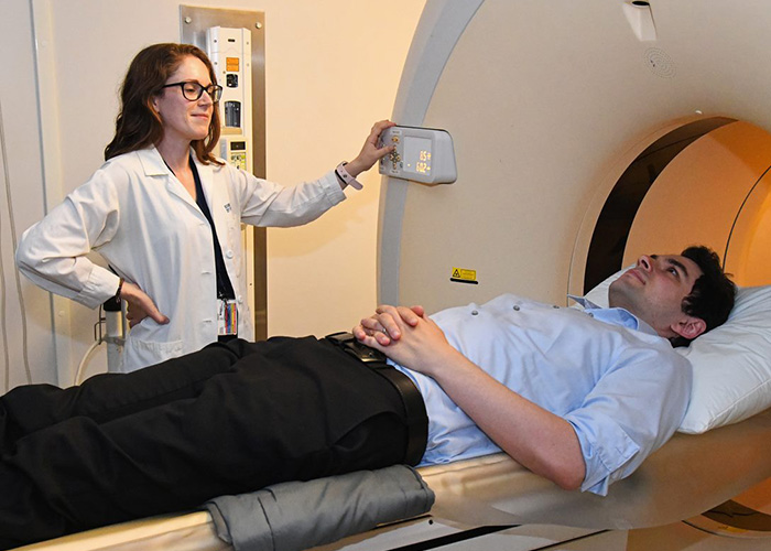  Dr. Katherine Turk, a neurologist at VA Boston, carries out a demonstration of amyloid PET imaging with Dr. Garrett Friedman, a behavioral neurology fellow at VA Boston. (Photo by Win Danielson)