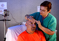 Rosario Carballo demonstrates the placement of electrodes on Herblay Alonso. Both are on staff at the Epilepsy Center of Excellence at the Miami VA Medical Center.