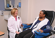 Dr. Karen Saban and research participant Bianca Calhoun demonstrate the EndoPAT machine, used to measure blood vessel elasticity. (Photo by Daniel DuVerney, Edward Hines, Jr. VA Hospital, Chicago)