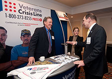 VA Secretary Robert McDonald visits the Veterans Crisis Line table at the suicide-prevention summit held in February. <em>(Photo by Robert Turtil)</em> 