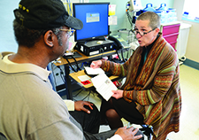 Study coordinator Elaine Nevins explains a colorectal cancer screening procedure to Navy Veteran Alex Pryor at the Puget Sound VA in 2012. <em>(Photo by Christopher Pacheco)</em>