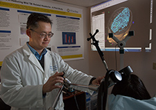 Dr. Albert Leung is testing whether transcranial magnetic stimulation can ease headaches associated with head trauma. <em>(Photo by Kevin Walsh)</em>